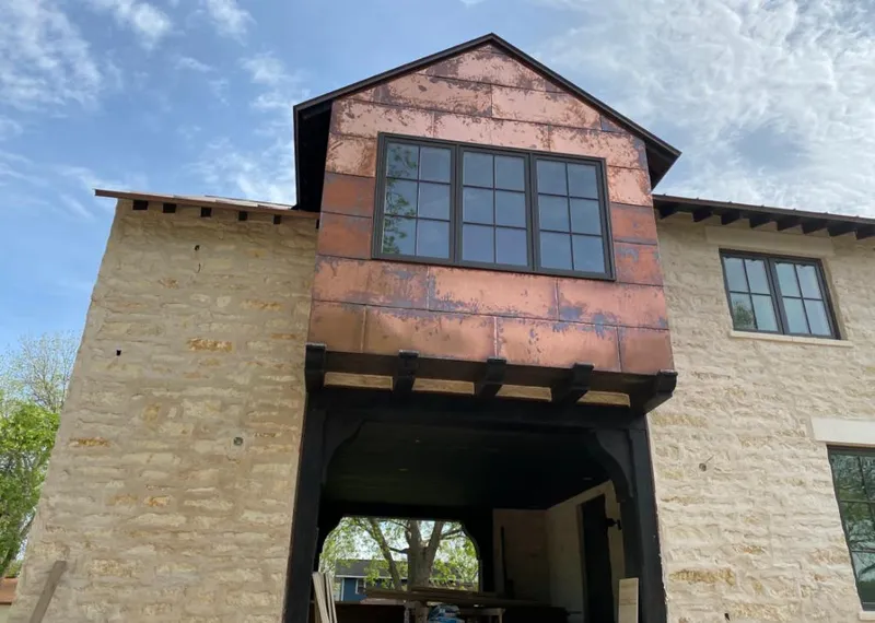 Copper metal panel facade on a stone building for Skylight Installation in Brandon